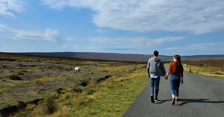 couple walking hand in hand in the Durham Dales countryside